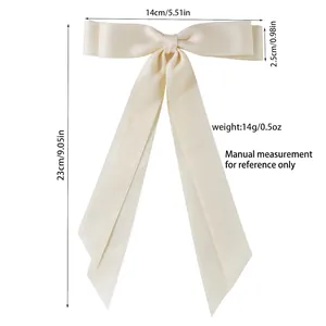 Cream white satin long ribbon bow hair clip with measurement guide on white background