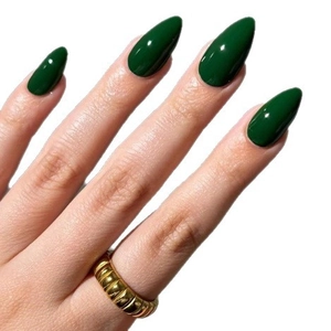 Glossy dark green almond press-on nails with a gold croissant ring on white background