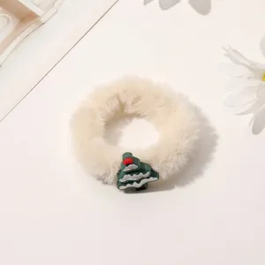 Close-up of fluffy white Christmas scrunchie with a cute green tree ornament