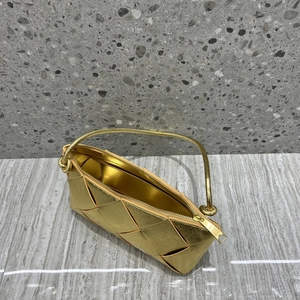 Top view detail of gold woven leather texture and elegant chain handle on small square bag