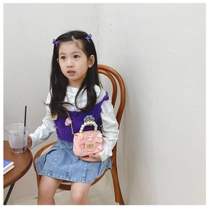 Pink quilted girls' bag with pearl handle and cute rabbit charm shown on a model