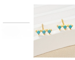 Detail view of gold-plated S925 silver stud earrings with three sky blue zircon stones