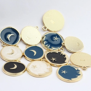 Macro shot of celestial alloy charms with star and moon enamel details in blue and black