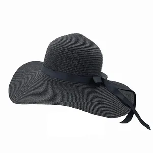 Dettaglio cappello di paglia nero a tesa larga con elegante nastro e fiocco
