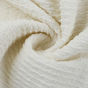 Vue macro de la texture du tissu seersucker crème sur une robe longue de vacances légère