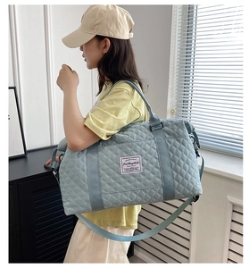 Adjustable shoulder strap detail on light blue quilted rhombic pattern gym bag