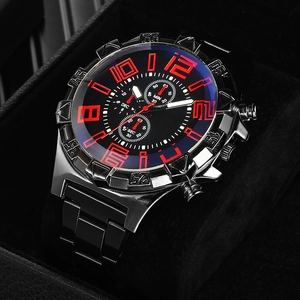 Macro shot of black stainless steel watch dial with red numerals and chronograph sub-dials