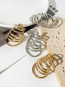 Macro detail of layered spiral spring earrings in polished gold and silver finish