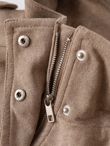 Detailaufnahme des braunen Wildleder-Jackenkragens mit silbernem Reißverschluss und Knöpfen