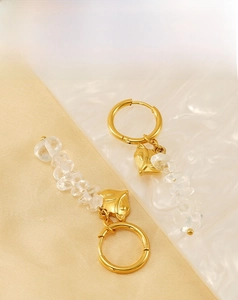 Detailed shot of golden fox earrings with clear natural stones and polished hoop clips