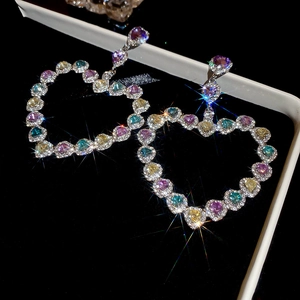 Détail des boucles d'oreilles cœur multicolores avec strass pavés étincelants
