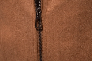 Macro shot of durable metal zipper puller and soft brown suede texture on jacket