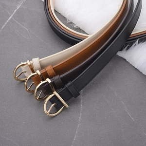 Detail view of four leather belts in beige, brown, and black with golden D-shaped buckles