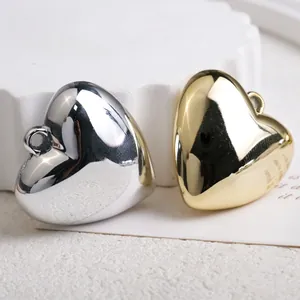 Polished heart pendants in gold and silver finish on white textured background