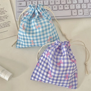 Close-up of drawstring organizers with blue and purple plaid patterns and pink bows