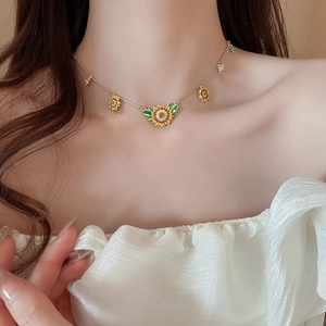 Golden sunflower necklace with green leaf details on female collarbone for elegant look