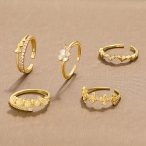 Five gold adjustable open rings set with opal flowers and hearts in luxury minimalist style