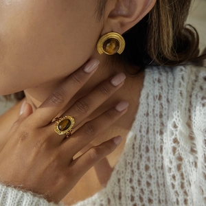 Detail shot of tiger eye stone jewelry set featuring golden oval earrings and matching ring