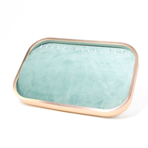Detailed side view of rose gold jewelry tray with mint green velvet ring slots