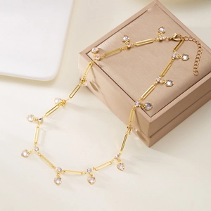 Detail of gold ankle bracelet featuring elegant heart charms and rectangular chain links