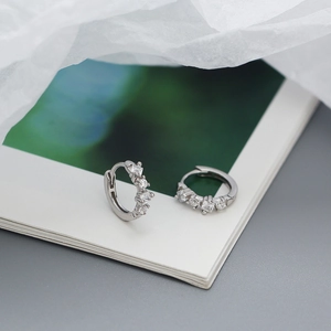 Detail view of 925 sterling silver hoop earrings featuring four square white zircons