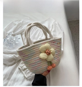 Detail of bohemian hand-woven cotton tote bag with floral decor and cherry charms