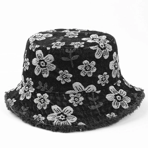 Detail of floral embroidery and frayed edges on black denim bucket hat for women