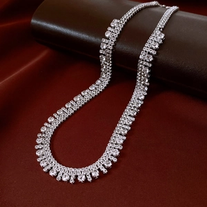 Dettaglio di una collana a nappine multistrato in argento con zirconi su rotolo in pelle