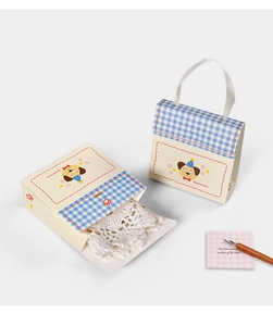 Close-up of beige gift box with blue checkers, cartoon dog, and handle for small gifts