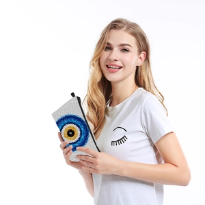Waterproof toiletry bag with Evil Eye print and zipper closure held by a model
