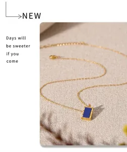 Macro detail of a 18K gold-plated lapis lazuli square pendant necklace on white background