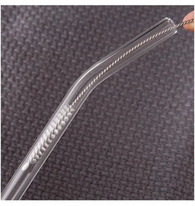 Macro shot of a flexible stainless steel cleaning brush inside a glass drinking straw