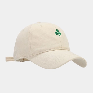 Detailed close-up of green shamrock embroidery on a beige cotton baseball cap