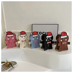Five gingerbread-shaped crossbody bags in various colors with golden chain straps and festive hats
