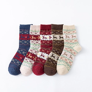 Five pairs of winter wool socks with reindeer and snowflake patterns in a variety of colors