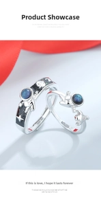 Macro detail of astronaut couple rings with blue starry glaze and adjustable silver band