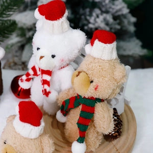 Christmas teddy bears in festive scarves and hats on rustic wood base for holiday decor
