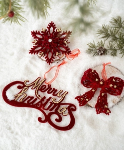 Détail de flocons de neige floqués rouges et plaque Merry Christmas avec paillettes dorées
