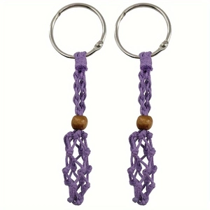 Détail de porte-clés en filet tissé violet avec perle en bois naturel et anneau métallique