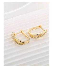 Macro detail of S925 sterling silver U-shaped hoop earrings with 14K gold and cubic zirconia