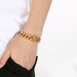 Detail of 12mm wide golden cuban curb link bracelet in polished stainless steel for men