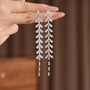 Detail view of silver leaf tassel earrings with sparkling zircon crystals in hand
