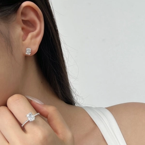 Gros plan sur une bague en zircone à coupe rectangulaire et des boucles d'oreilles assorties