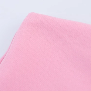 Close-up detail of pink fabric texture showing fine weave patterns on slit culottes