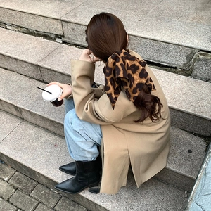 Close-up of a leopard print scrunchie tied on a low ponytail for a stylish look