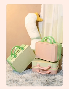 Three 14-inch mini hardshell vanity cases in green and pink with top handles and zippers