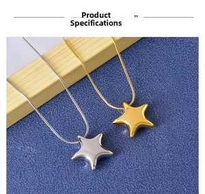 Detailed close-up of gold and silver star pendant necklaces on a blue background