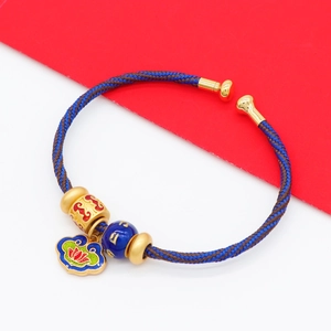 Handcrafted woven bracelet with colorful rope, gold beads, and a lotus enamel charm