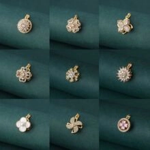 Detailed grid of nine assorted gold clover and flower pendants with cubic zirconia