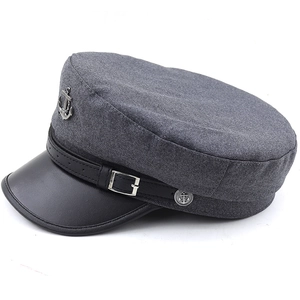 Détails de la casquette marin en laine gris foncé avec visière en cuir et badge ancre